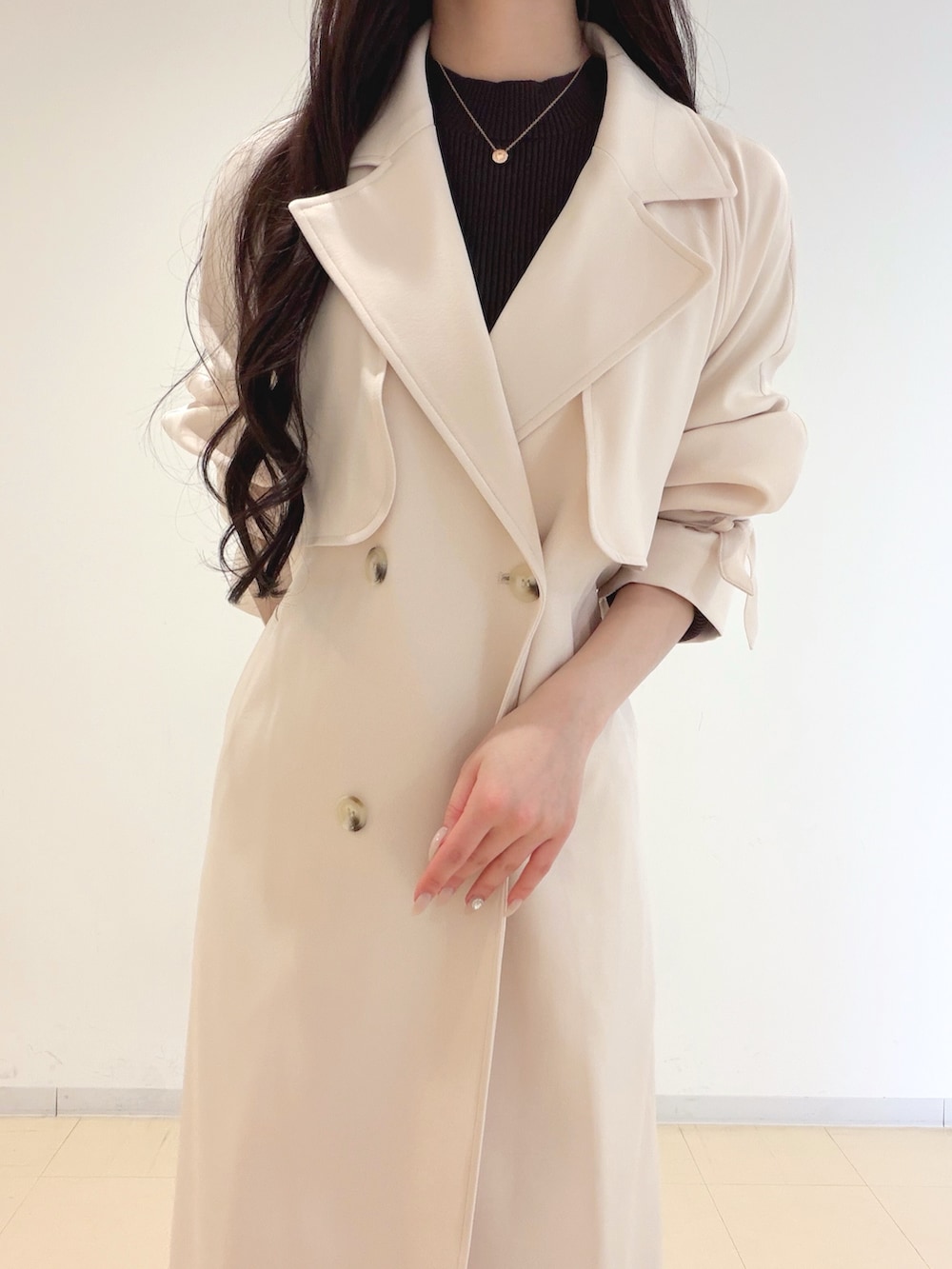 ホワイト系のスカート、ブラウン系のブーツ、ホワイト系のショルダーバッグを着用したレディースの冬コーディネートの6枚目の写真