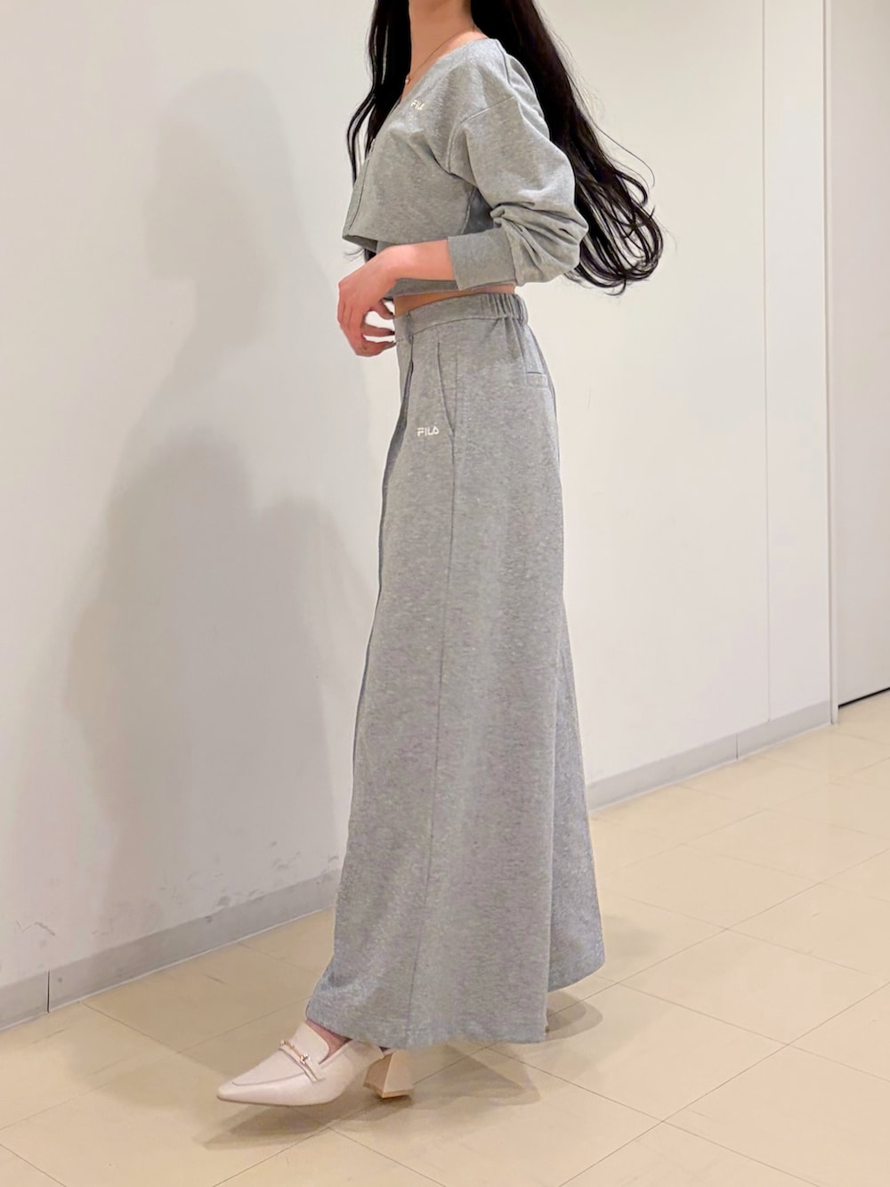 グレー系のその他パンツ、グレー系のTシャツ/カットソー、ホワイト系のパンプスを着用したレディースの冬コーディネートの4枚目の写真