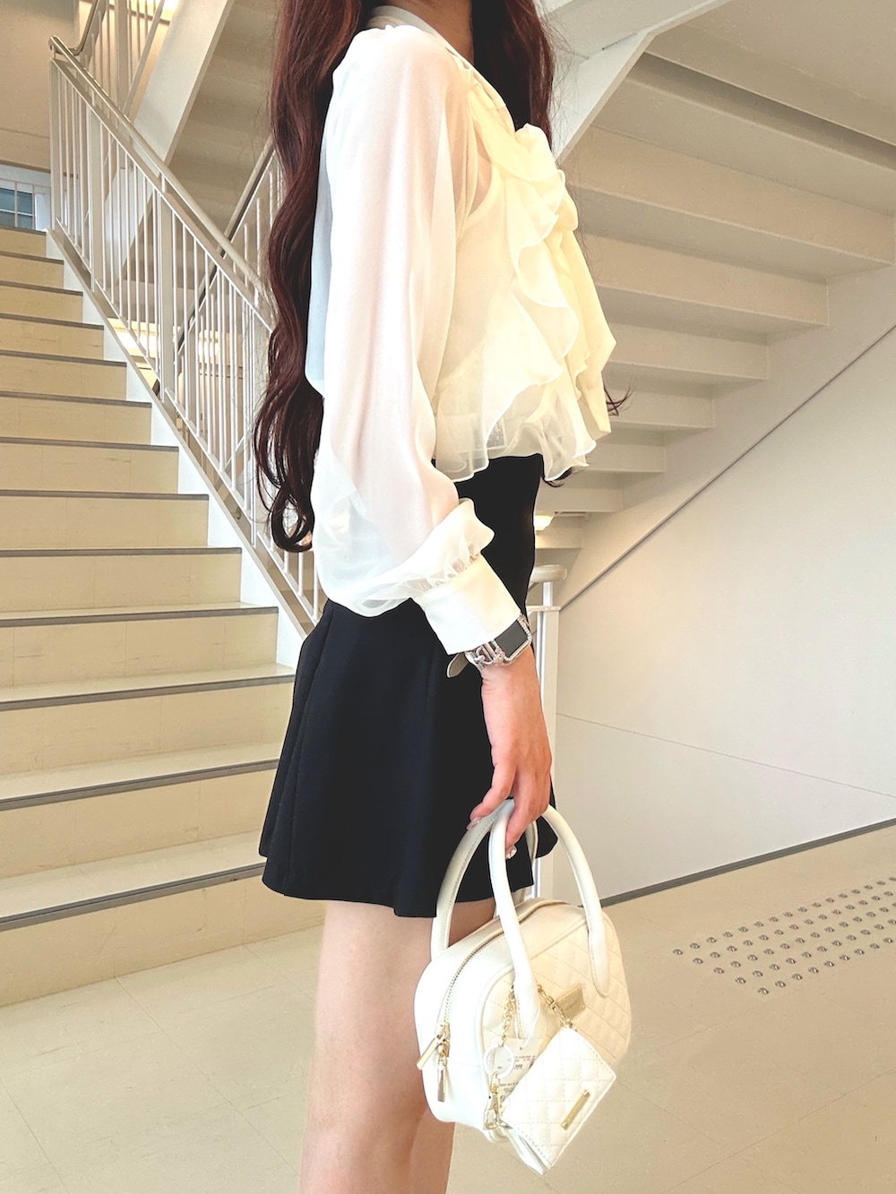 ホワイト系のシャツ/ブラウス、ブラック系のスカート、ブラウン系のブーツを着用したレディースの秋コーディネートの5枚目の写真