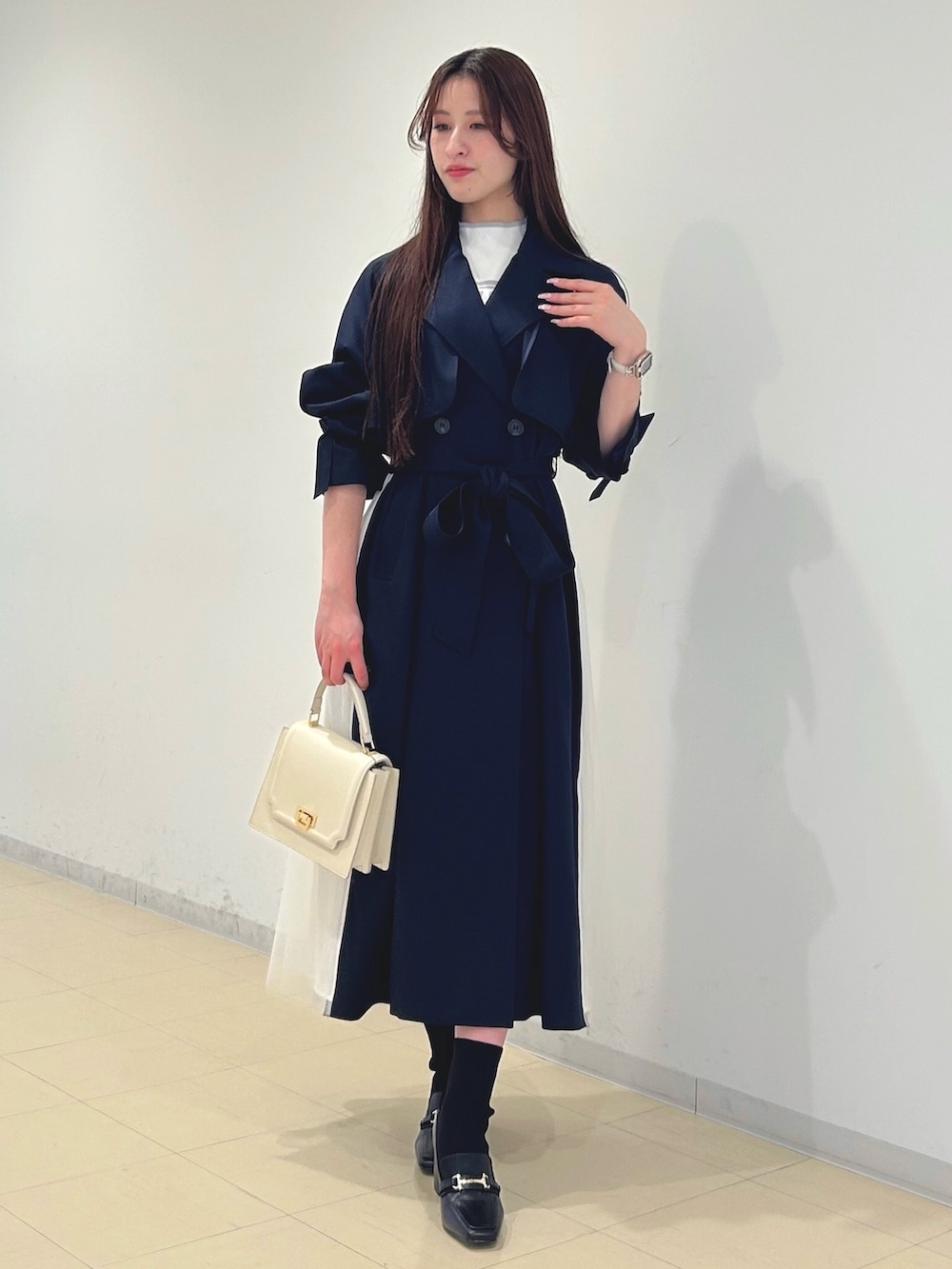 ブラック系のブーツ、ホワイト系のハンドバッグ、ホワイト系のニット/セーターを着用したレディースの春コーディネートの3枚目の写真