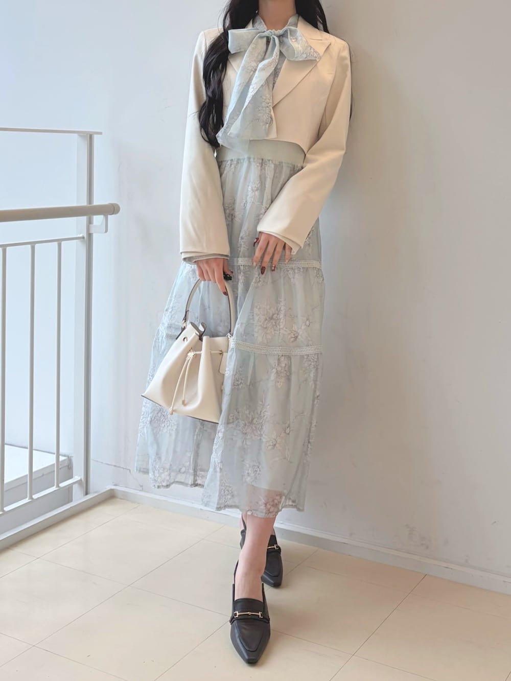 グリーン系のワンピース、ホワイト系のショルダーバッグ、ブラウン系のパンプスを着用したレディースの冬コーディネートの2枚目の写真