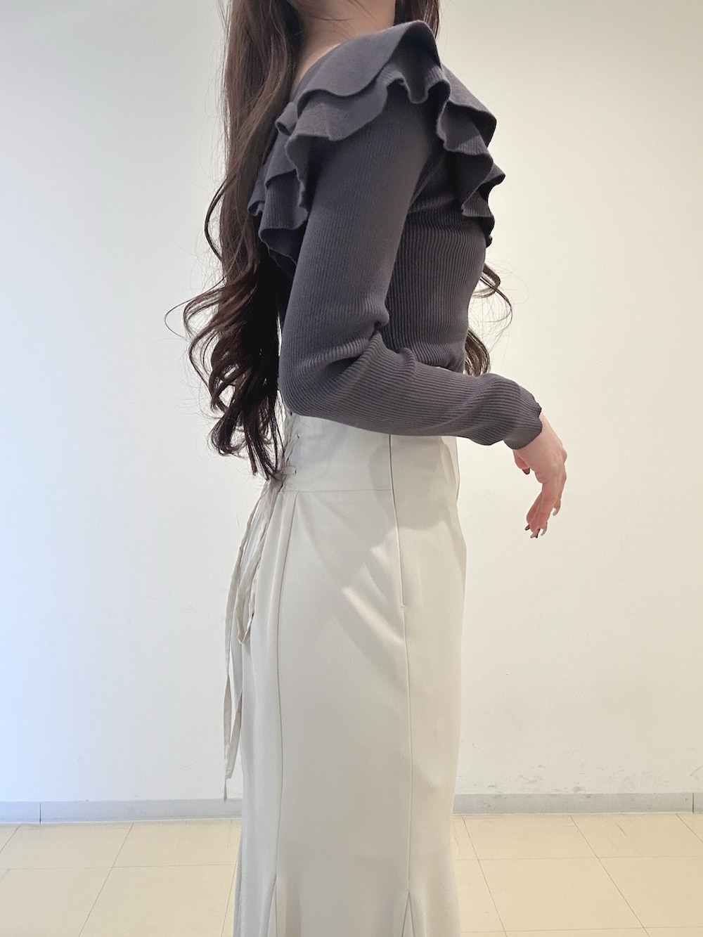 ホワイト系のスカート、ブラック系のブーツ、グレー系のニット/セーターを着用したレディースの冬コーディネートの6枚目の写真