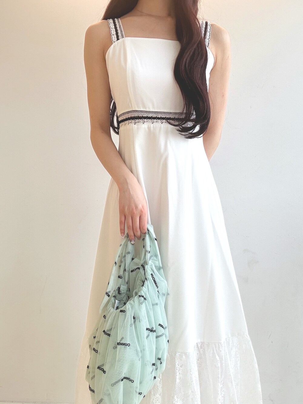 ホワイト系のワンピース、ブラウン系のサンダル、グリーン系のハンドバッグを着用したレディースの夏コーディネートの5枚目の写真