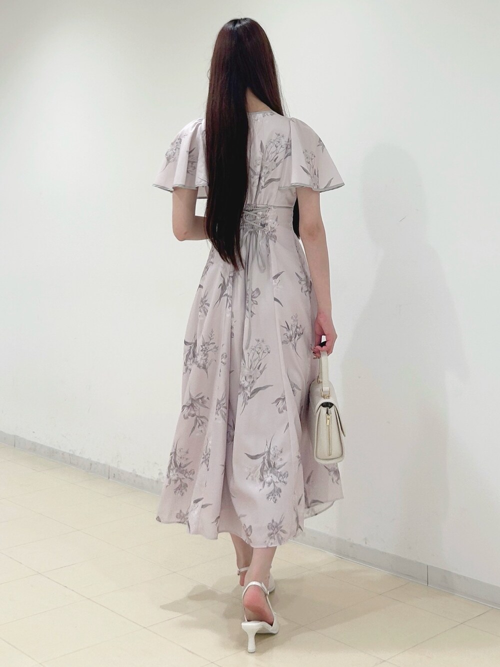 ピンク系のワンピース、ホワイト系のハンドバッグ、ホワイト系のパンプスを着用したレディースの夏コーディネートの4枚目の写真