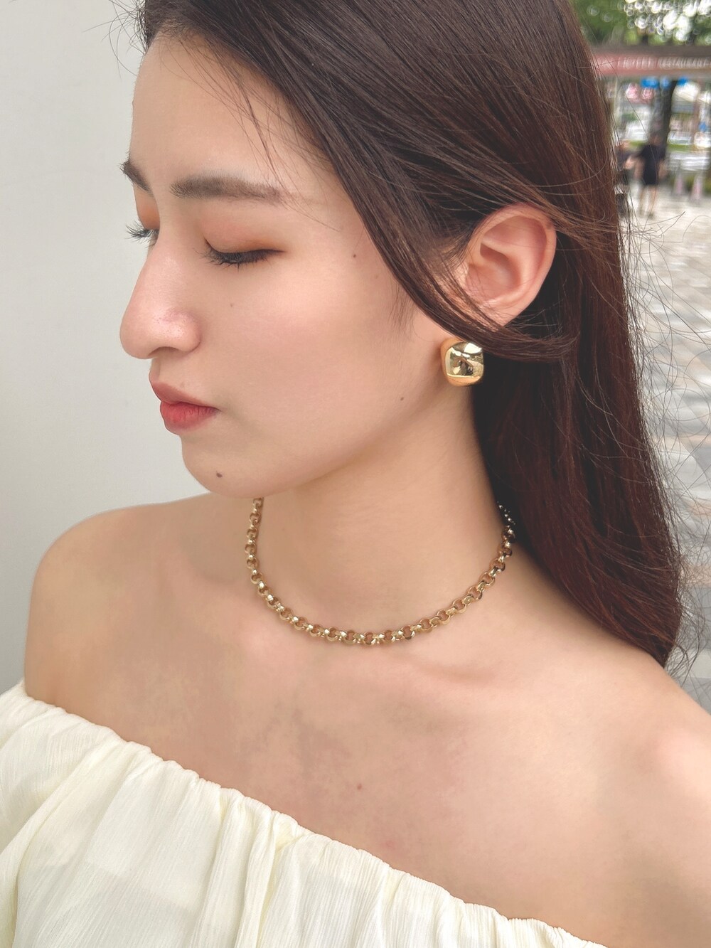 ホワイト系のシャツ/ブラウス、ベージュ系のスカート、ホワイト系のハンドバッグを着用したレディースの夏コーディネートの3枚目の写真