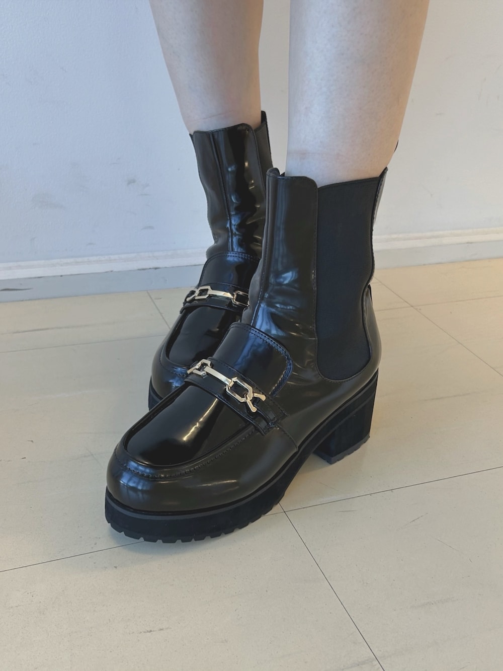 ブラウン系のワンピース、ホワイト系のハンドバッグ、ブラック系のブーツを着用したレディースの秋コーディネートの7枚目の写真