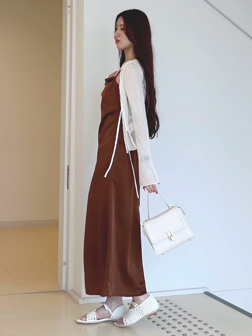 ブラウン系のワンピース、ホワイト系のチューブトップ、ホワイト系のハンドバッグを着用したレディースの夏コーディネートの2枚目の写真