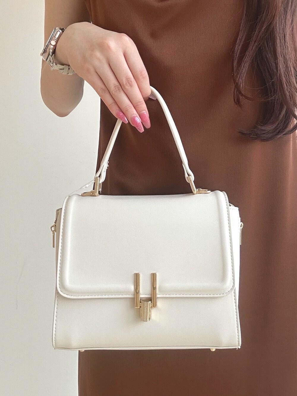 ブラウン系のワンピース、ホワイト系のハンドバッグ、ホワイト系のチューブトップを着用したレディースの夏コーディネートの8枚目の写真