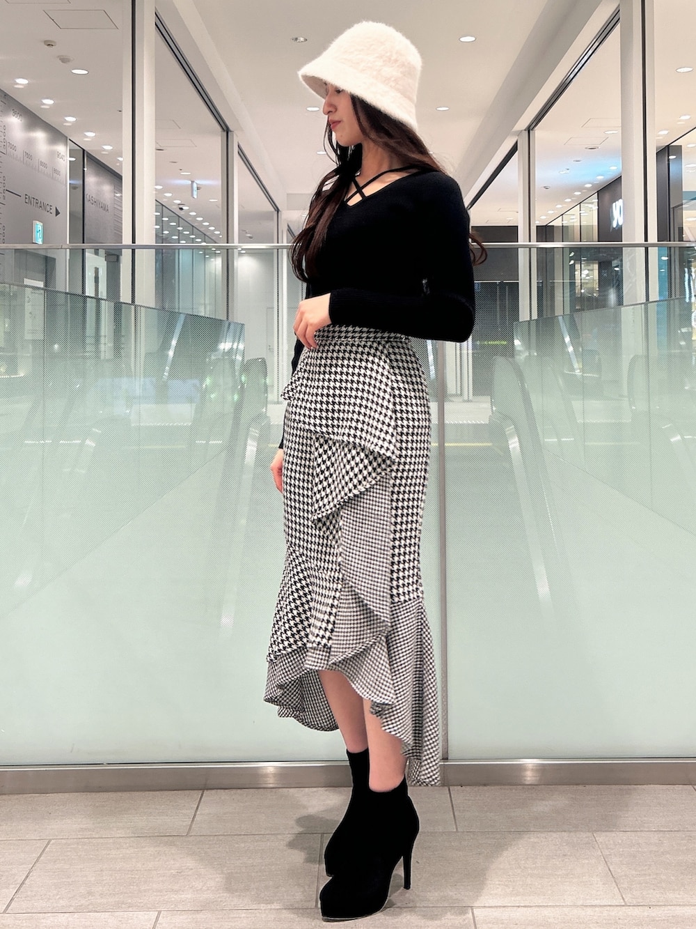 ブラック系のニット/セーター、ブラック系のブーツ、その他のスカートを着用したレディースの冬コーディネートの2枚目の写真