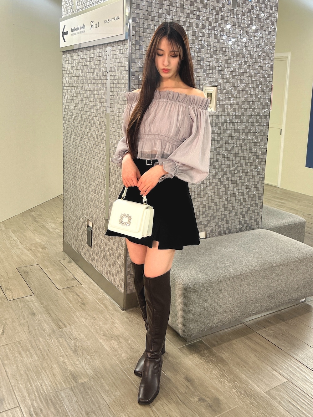 パープル系のシャツ/ブラウス、ホワイト系のショルダーバッグ、ブラウン系のブーツを着用したレディースの冬コーディネートの2枚目の写真