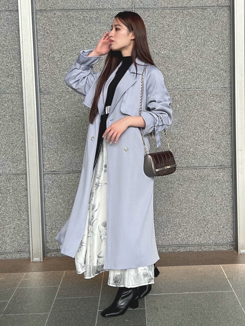 ブラック系のワンピース、ブルー系のトレンチコート、ブラウン系のハンドバッグを着用したレディースの秋コーディネートの3枚目の写真