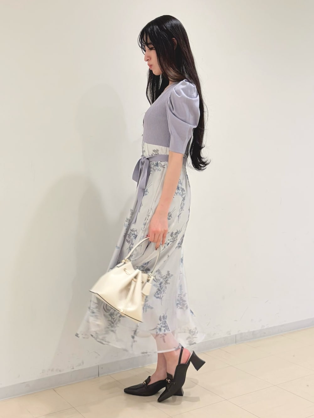 パープル系のワンピース、ホワイト系のショルダーバッグ、ブラウン系のパンプスを着用したレディースの冬コーディネートの2枚目の写真