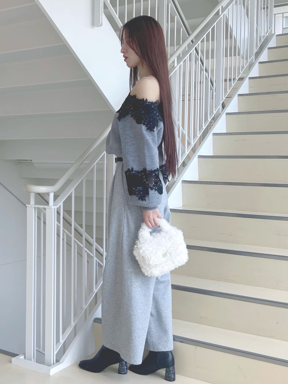 グレー系のニット/セーター、グレー系のその他パンツ、ブラック系のブーツを着用したレディースの秋コーディネートの2枚目の写真