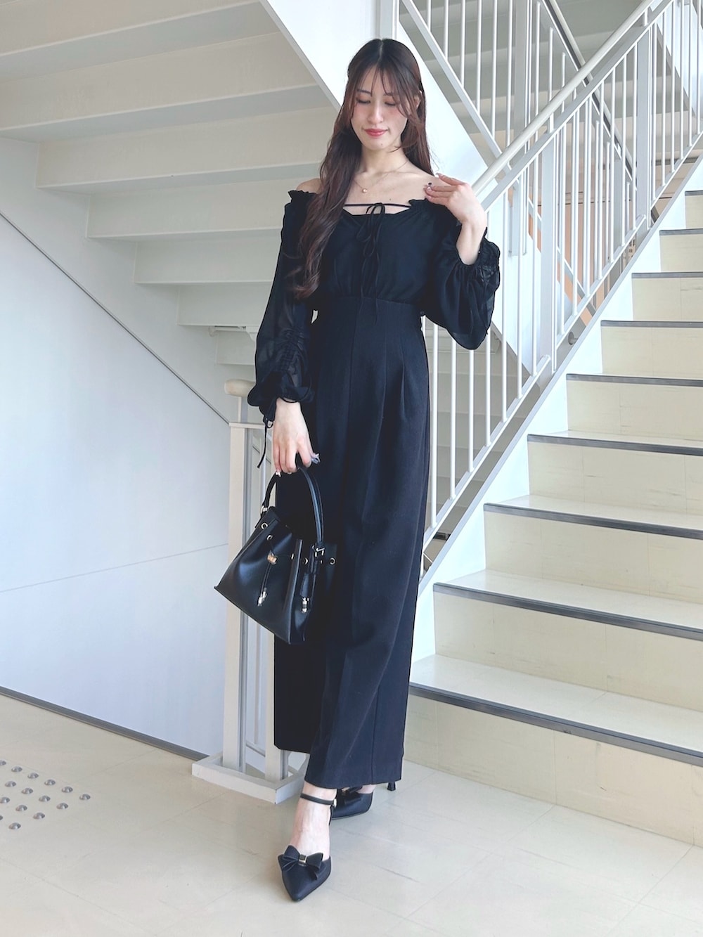 ブラック系のワンピース、ブラック系のショルダーバッグ、ブラック系のパンプスを着用したレディースの秋コーディネートの3枚目の写真