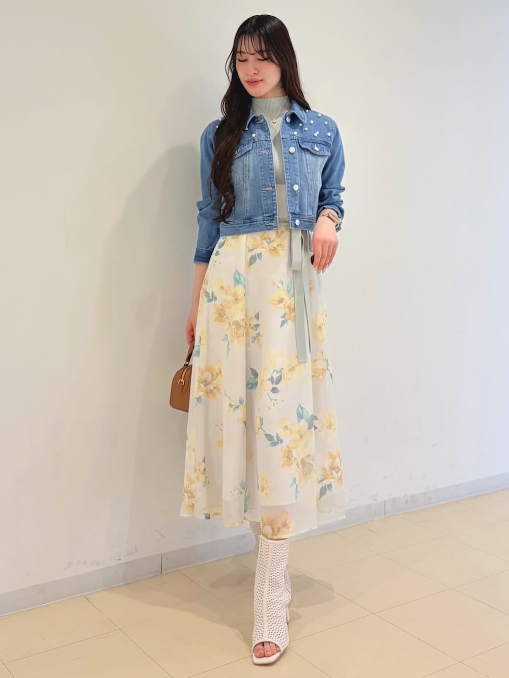 グリーン系のワンピース、ブルー系のデニムジャケット、ブラウン系のハンドバッグを着用したレディースの春コーディネートの4枚目の写真