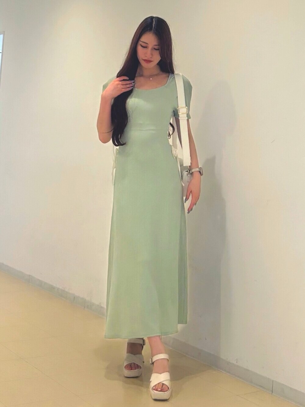 ホワイト系のサンダル、ホワイト系のショルダーバッグ、グリーン系のワンピースを着用したレディースの夏コーディネートの3枚目の写真