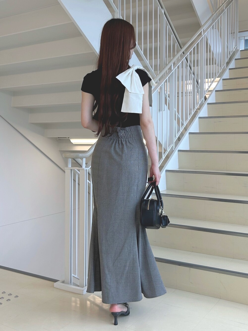 グレー系のパンプス、その他のスカート、ブラック系のニット/セーターを着用したレディースの夏コーディネートの4枚目の写真