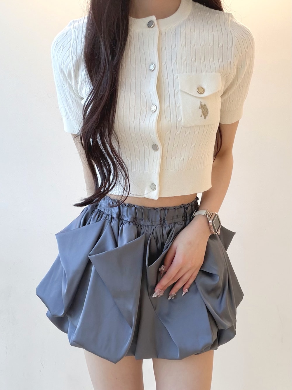 グレー系のスカート、ホワイト系のカーディガン/ボレロ、ホワイト系のサンダルを着用したレディースの夏コーディネートの4枚目の写真