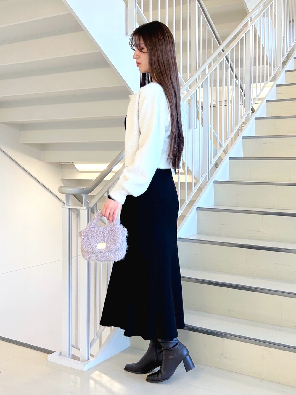 ブラック系のワンピース、ブラック系のキャミソール、ホワイト系のカーディガン/ボレロを着用したレディースの冬コーディネートの2枚目の写真