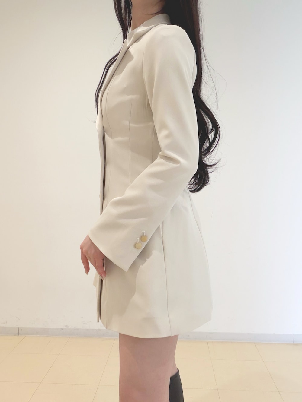 ホワイト系のワンピース、ホワイト系のニット/セーター、ブラック系のハンドバッグを着用したレディースの冬コーディネートの5枚目の写真