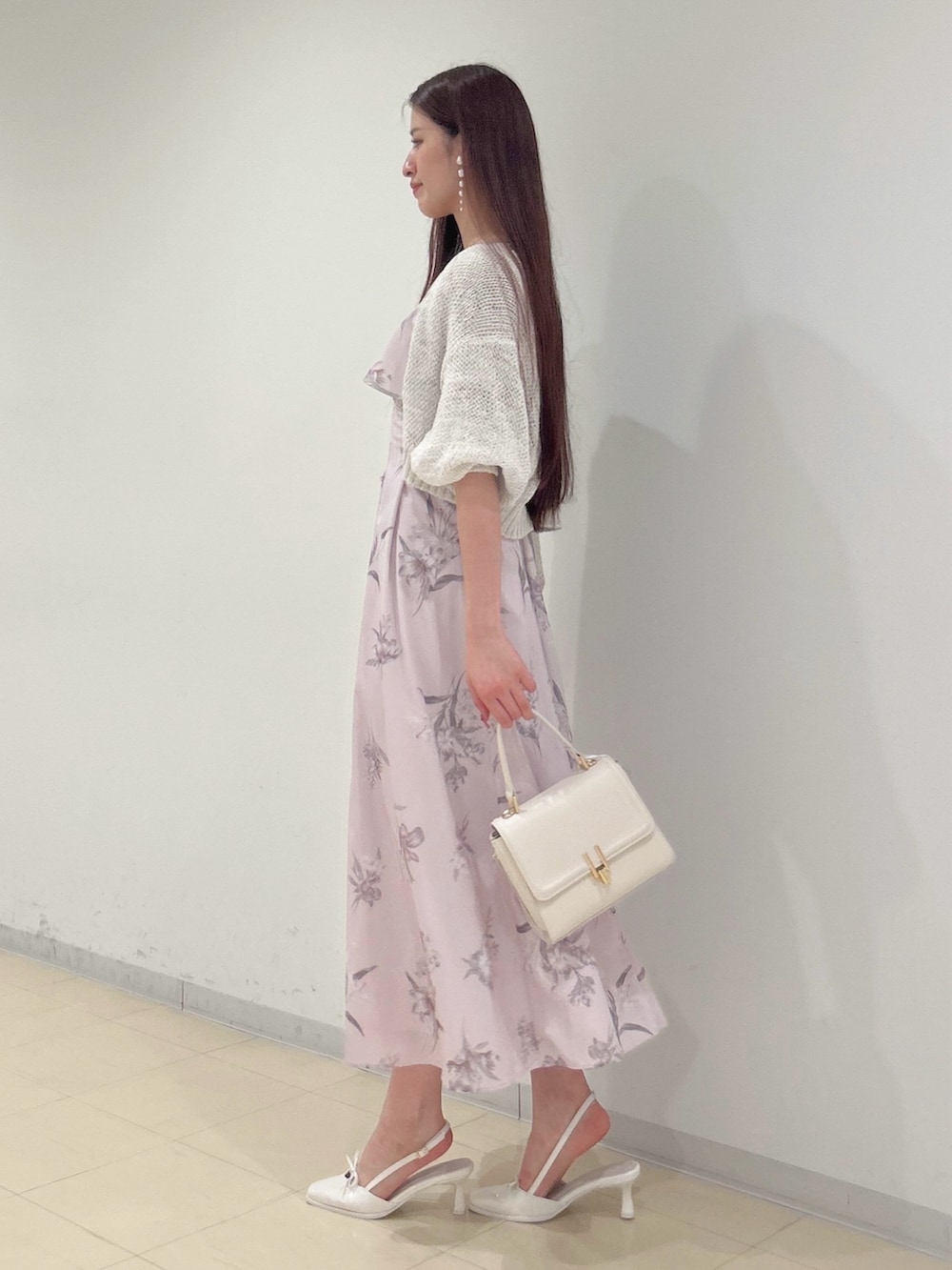 ピンク系のワンピース、ホワイト系のパンプス、ホワイト系のハンドバッグを着用したレディースの夏コーディネートの2枚目の写真