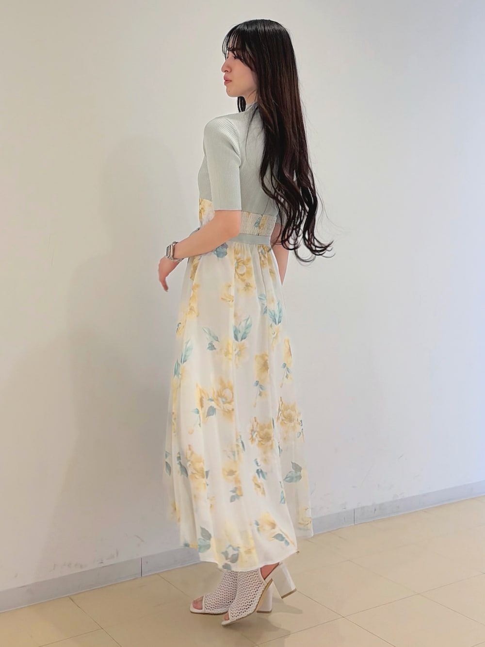 グリーン系のワンピース、ブルー系のデニムジャケット、ブラウン系のハンドバッグを着用したレディースの春コーディネートの3枚目の写真