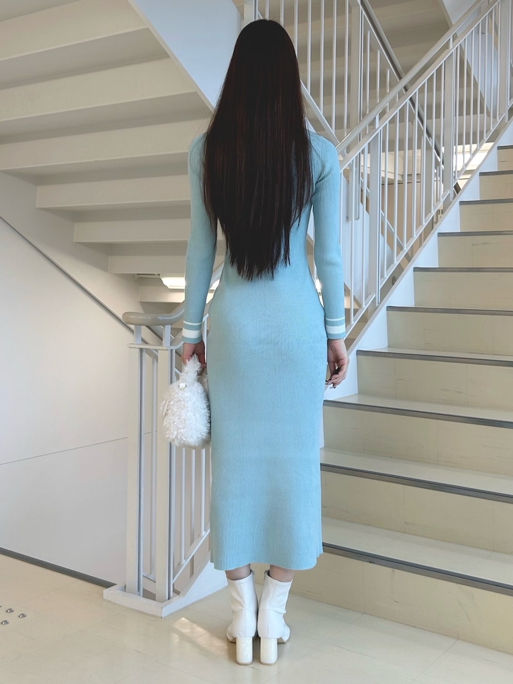 グリーン系のワンピース、ホワイト系のハンドバッグ、ホワイト系のブーツを着用したレディースの秋コーディネートの4枚目の写真