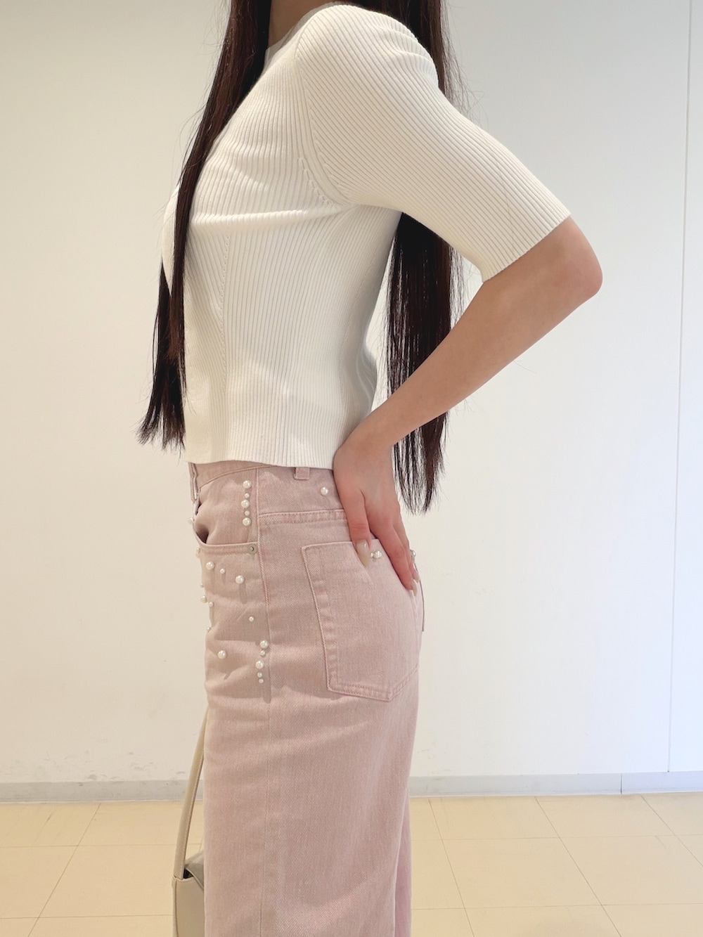 ホワイト系のニット/セーター、ホワイト系のキャミソール、ピンク系のデニムパンツを着用したレディースの春コーディネートの4枚目の写真