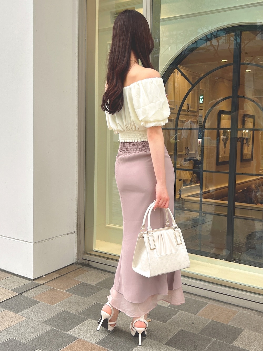 ホワイト系のシャツ/ブラウス、ベージュ系のスカート、ホワイト系のハンドバッグを着用したレディースの夏コーディネートの2枚目の写真
