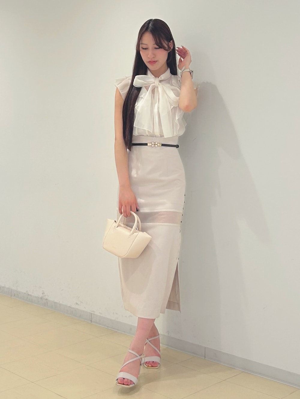 ピンク系のスカート、ベージュ系のサンダル、ホワイト系のシャツ/ブラウスを着用したレディースの春コーディネートの3枚目の写真