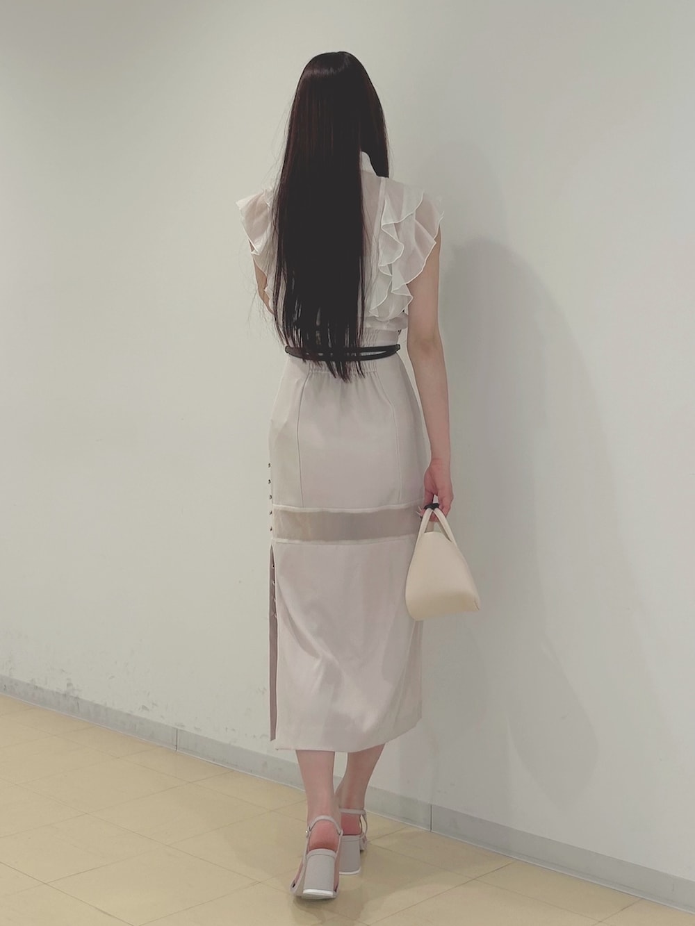 ピンク系のスカート、ベージュ系のサンダル、ホワイト系のシャツ/ブラウスを着用したレディースの春コーディネートの4枚目の写真