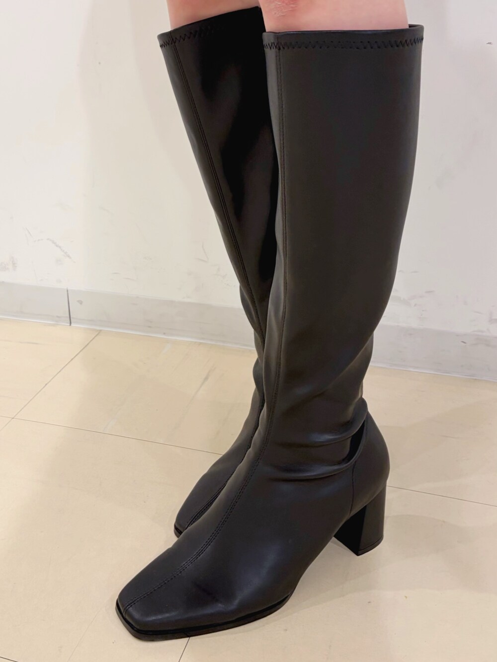 グリーン系のワンピース、ホワイト系のキャミソール、ホワイト系のショルダーバッグを着用したレディースの冬コーディネートの6枚目の写真