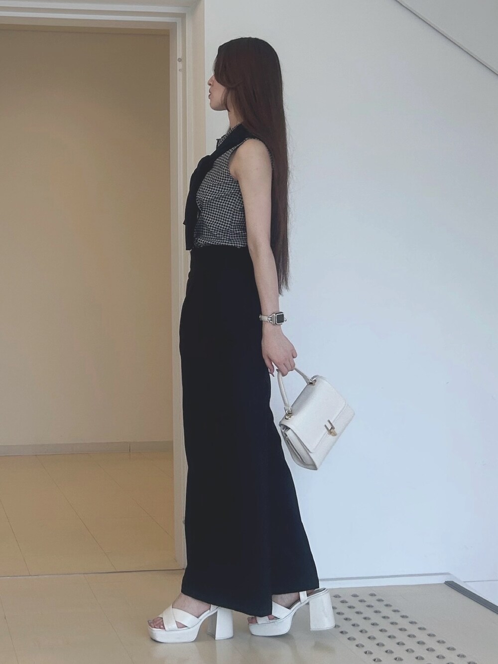 ブラック系のその他パンツ、ホワイト系のサンダル、ホワイト系のハンドバッグを着用したレディースの夏コーディネートの2枚目の写真
