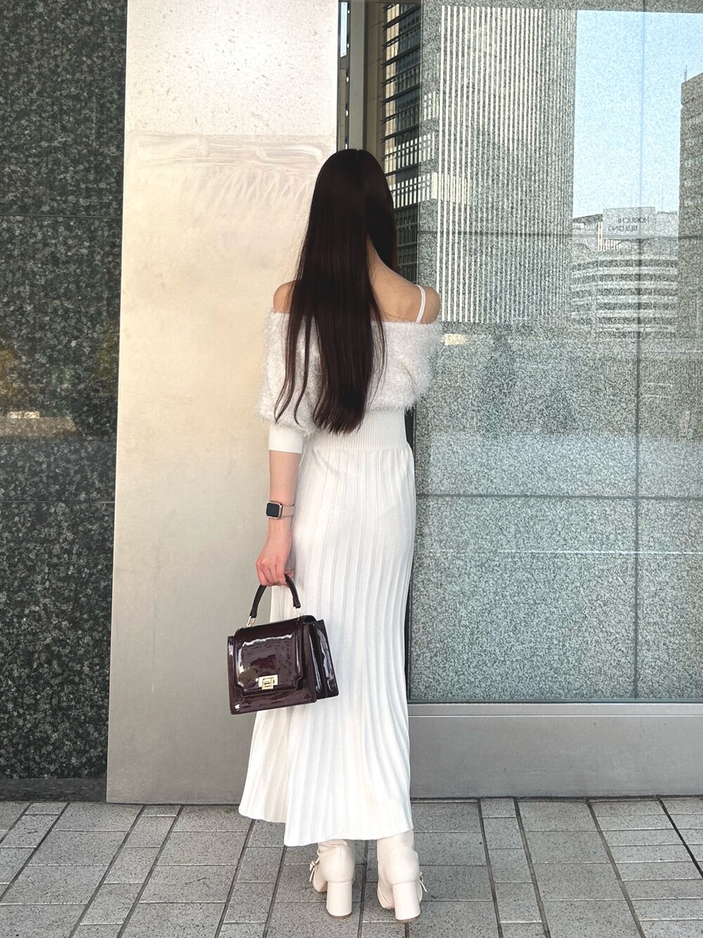 ホワイト系のワンピース、レッド系のハンドバッグ、ホワイト系のブーツを着用したレディースの冬コーディネートの3枚目の写真