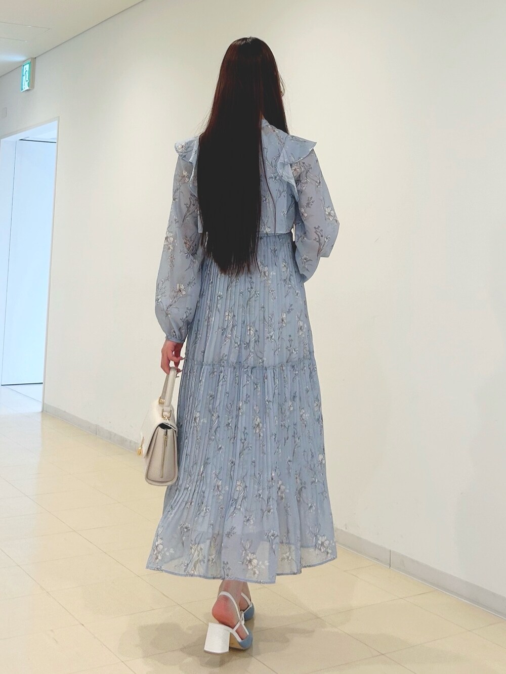 ブルー系のワンピース、ホワイト系のパンプス、ホワイト系のハンドバッグを着用したレディースの春コーディネートの4枚目の写真