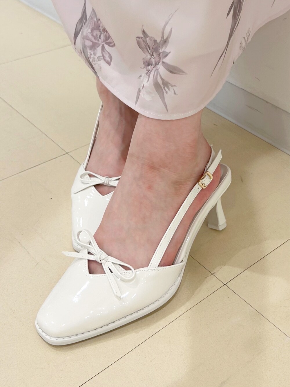 ピンク系のワンピース、ホワイト系のハンドバッグ、ホワイト系のパンプスを着用したレディースの夏コーディネートの8枚目の写真