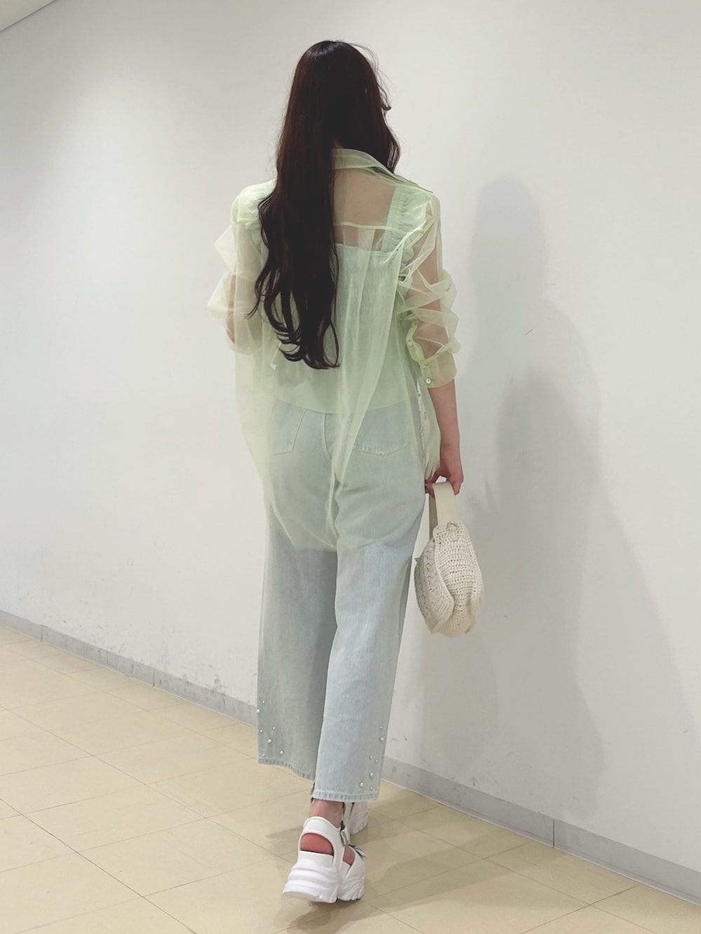 ブルー系のデニムパンツ、グリーン系のシャツ/ブラウス、ホワイト系のショルダーバッグを着用したレディースの春コーディネートの4枚目の写真