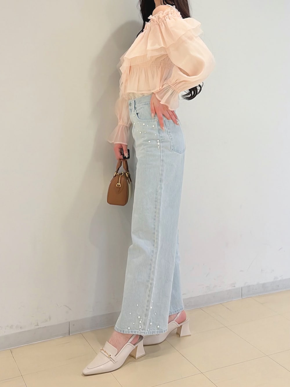 ピンク系のシャツ/ブラウス、ブルー系のデニムパンツ、ブラウン系のハンドバッグを着用したレディースの春コーディネートの5枚目の写真
