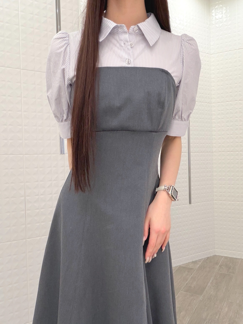 グレー系のワンピース、ホワイト系のハンドバッグ、ブラウン系のパンプスを着用したレディースの春コーディネートの4枚目の写真