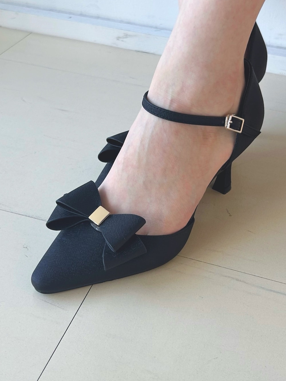 ブラック系のワンピース、ブラック系のショルダーバッグ、ブラック系のパンプスを着用したレディースの秋コーディネートの7枚目の写真