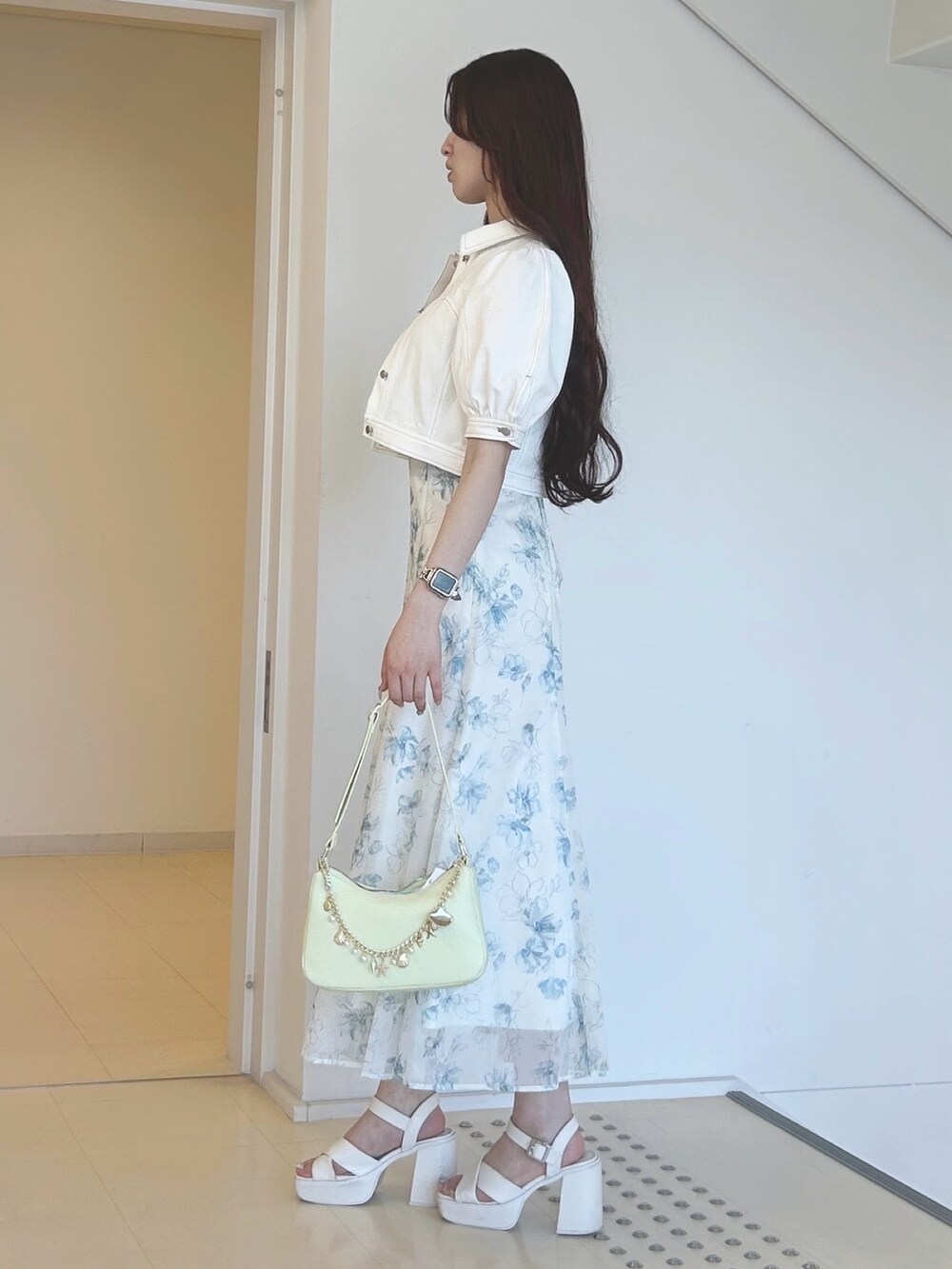 グリーン系のワンピース、グリーン系のハンドバッグ、ホワイト系のサンダルを着用したレディースの夏コーディネートの2枚目の写真