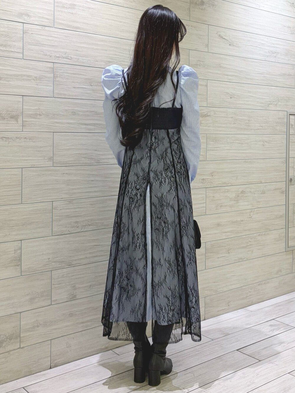 ブルー系のワンピース、ブラック系のハンドバッグ、ブラック系のブーツを着用したレディースの冬コーディネートの3枚目の写真