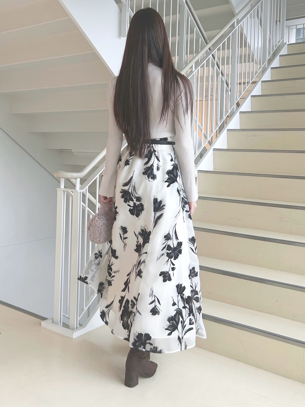 ホワイト系のスカート、ベージュ系のニット/セーター、ピンク系のハンドバッグを着用したレディースの秋コーディネートの4枚目の写真