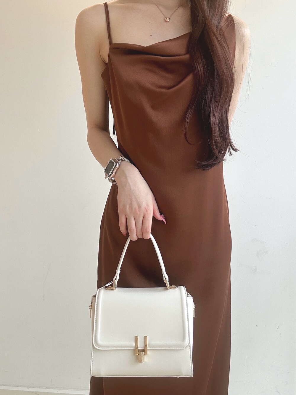 ブラウン系のワンピース、ホワイト系のハンドバッグ、ホワイト系のチューブトップを着用したレディースの夏コーディネートの5枚目の写真