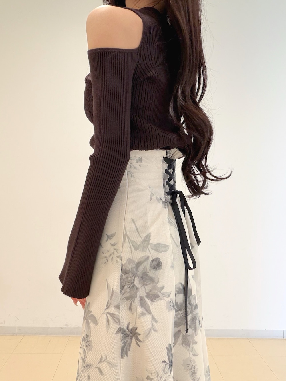 ホワイト系のスカート、ブラウン系のブーツ、ホワイト系のショルダーバッグを着用したレディースの冬コーディネートの7枚目の写真