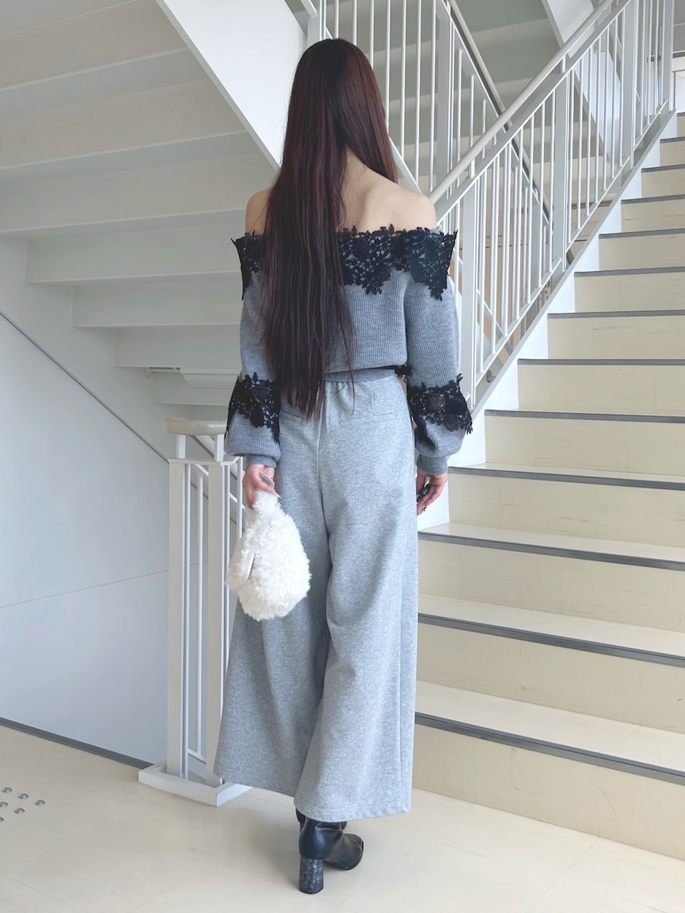 グレー系のニット/セーター、グレー系のその他パンツ、ブラック系のブーツを着用したレディースの秋コーディネートの3枚目の写真