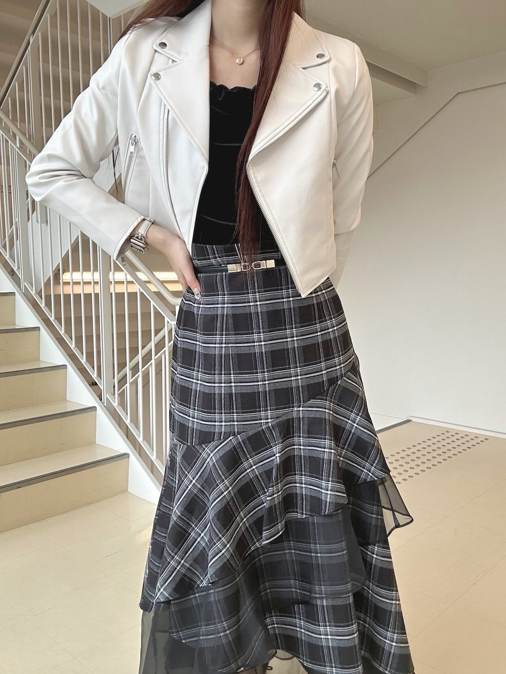 ブラック系のブーツ、ブラック系のスカート、ピンク系のハンドバッグを着用したレディースの秋コーディネートの5枚目の写真