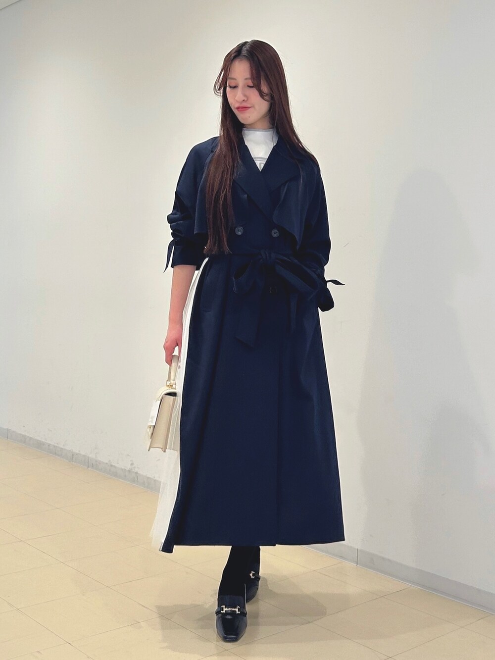 ブラック系のブーツ、ホワイト系のハンドバッグ、ホワイト系のニット/セーターを着用したレディースの春コーディネートの5枚目の写真