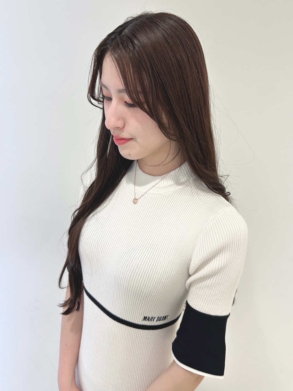ホワイト系のワンピース、ブラック系のショルダーバッグ、ホワイト系のブーツを着用したレディースの春コーディネートの6枚目の写真