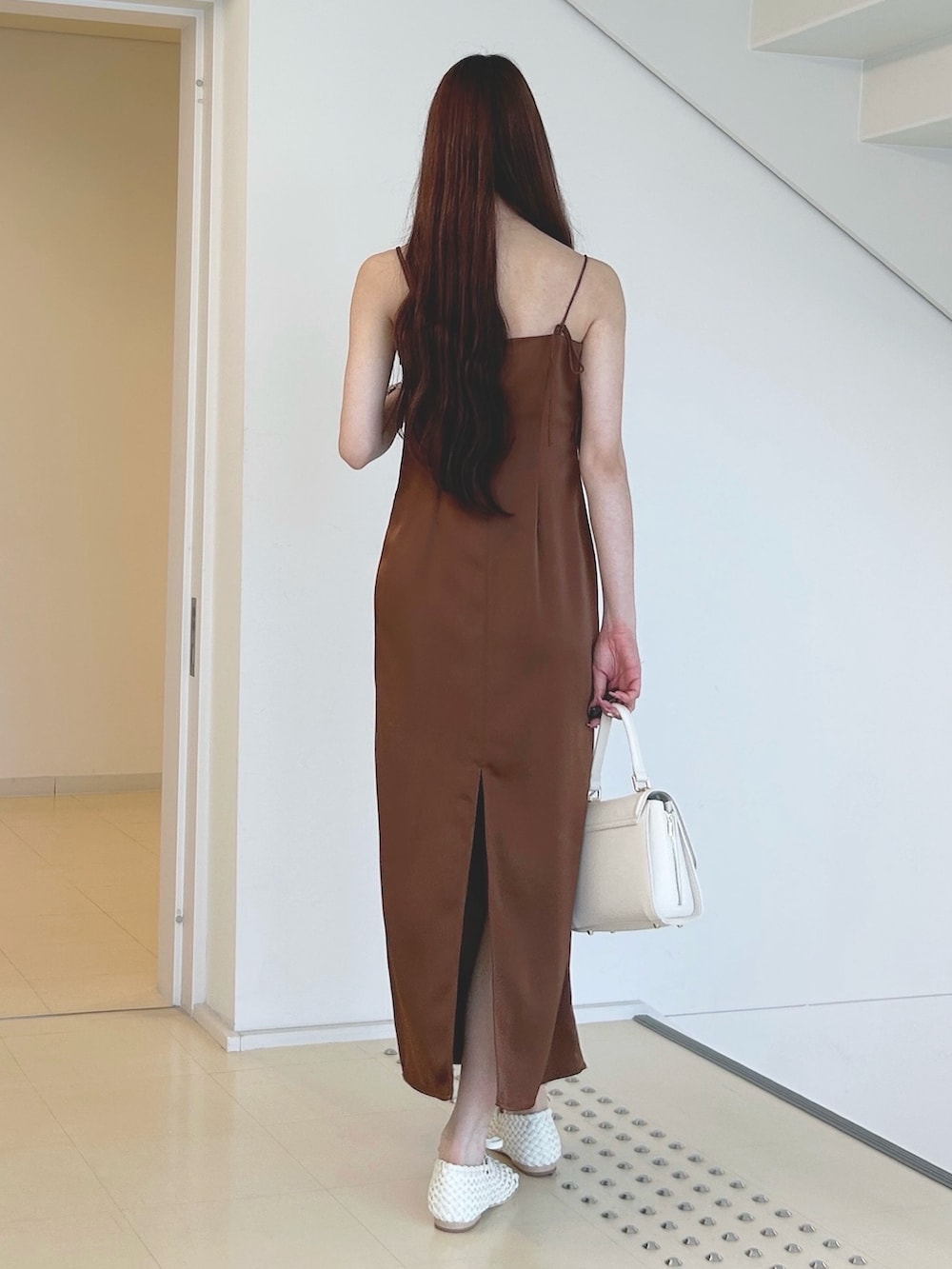 ブラウン系のワンピース、ホワイト系のハンドバッグ、ホワイト系のチューブトップを着用したレディースの夏コーディネートの4枚目の写真